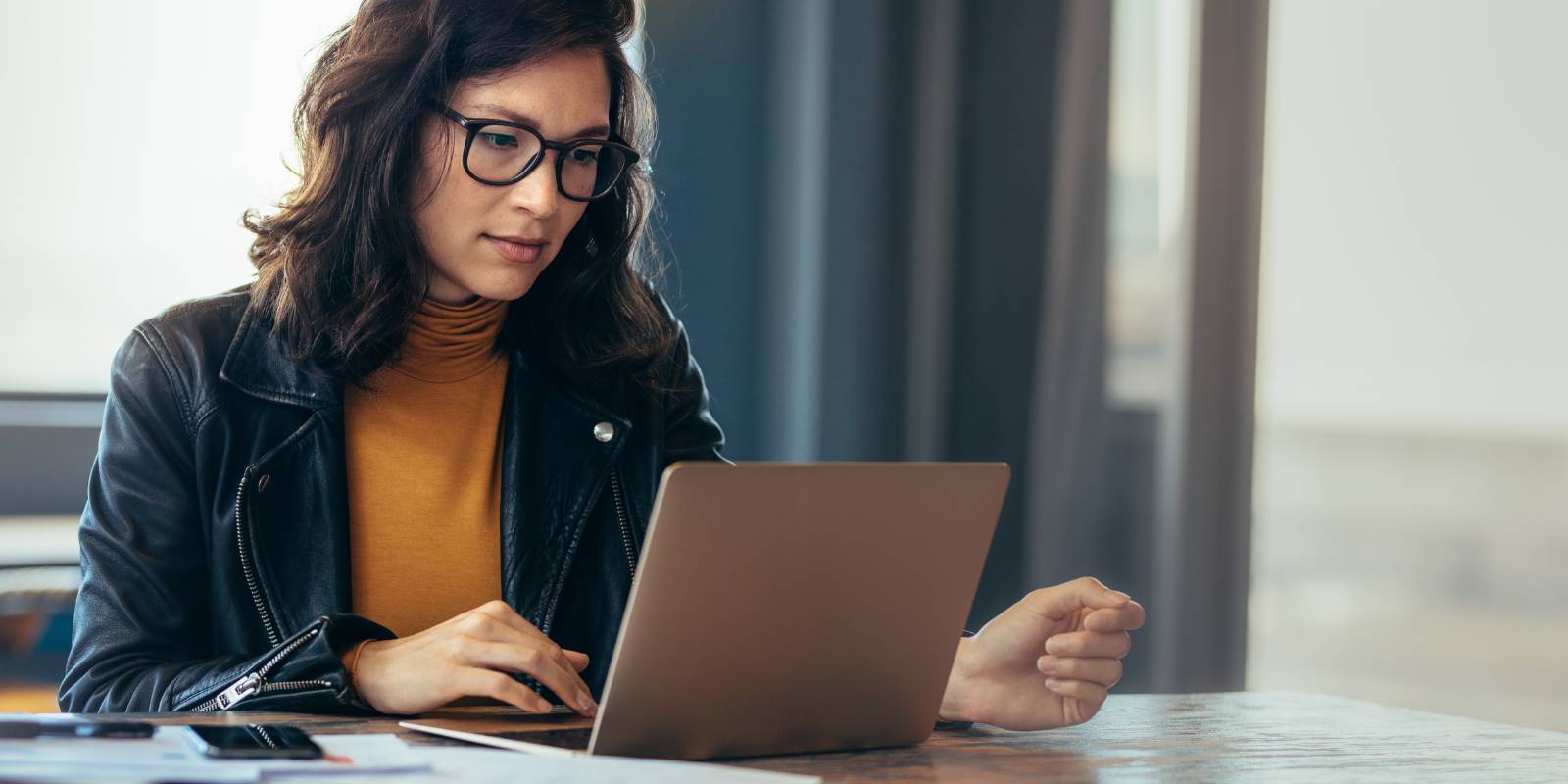Employer sitting at desk looking at laptop working