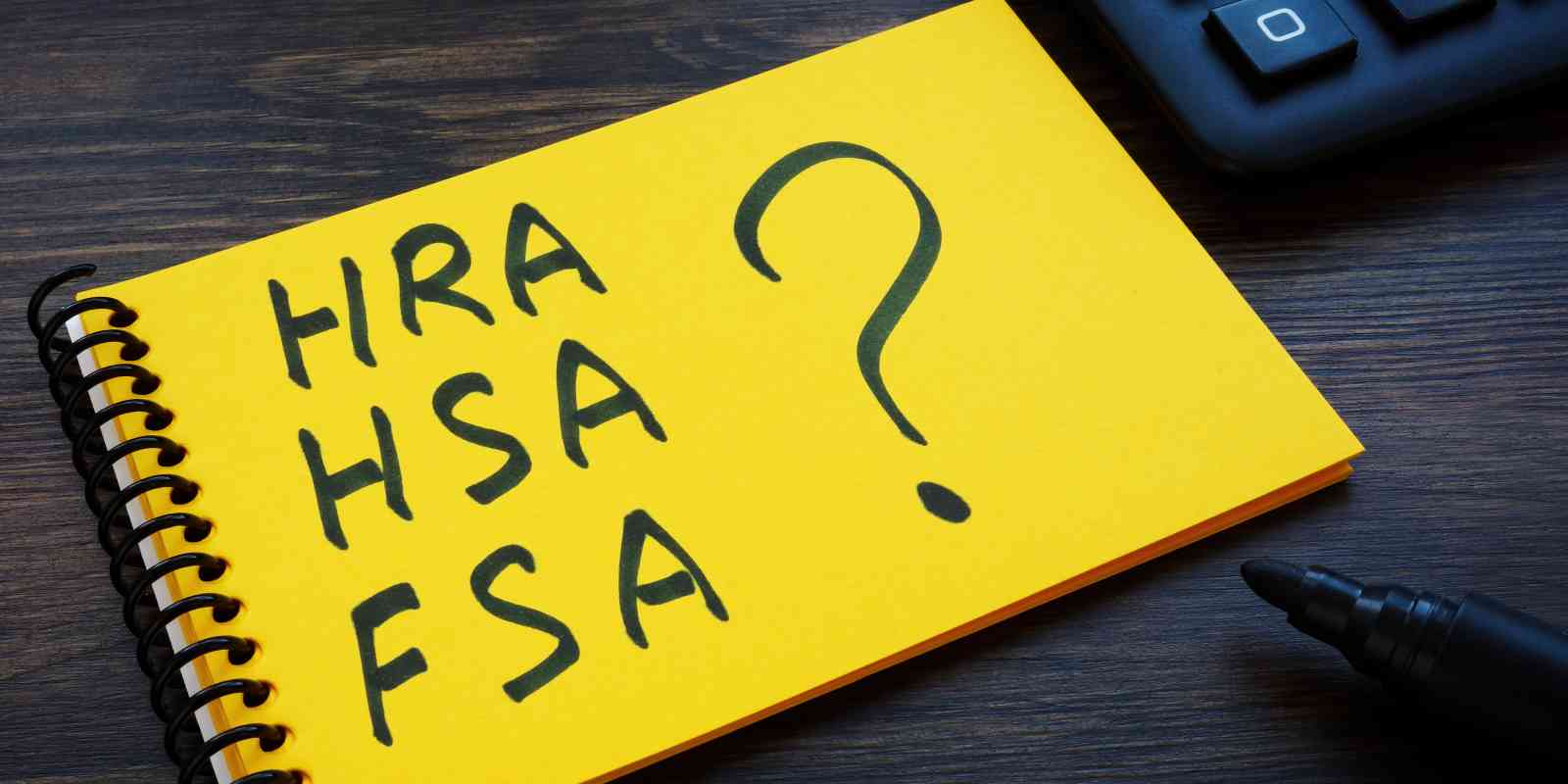 Notepad with notes on HRA, HSA, FSA