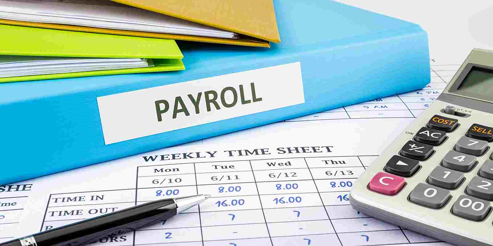 payroll binder, timesheet and calculator on a desk
